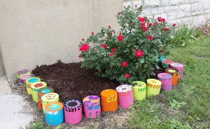 Submitted Photo Grundy R-5 Elementary School students used their artistic skills to improve the outside of the school building at Humphreys. The second through sixth grade students in Mrs. Lila Moore’s art class took cans from the kitchen trash, painted and repurposed them to line the flower beds and plants at the school. 